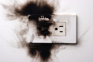 A dangerous situation shown with a burnt electronical socket